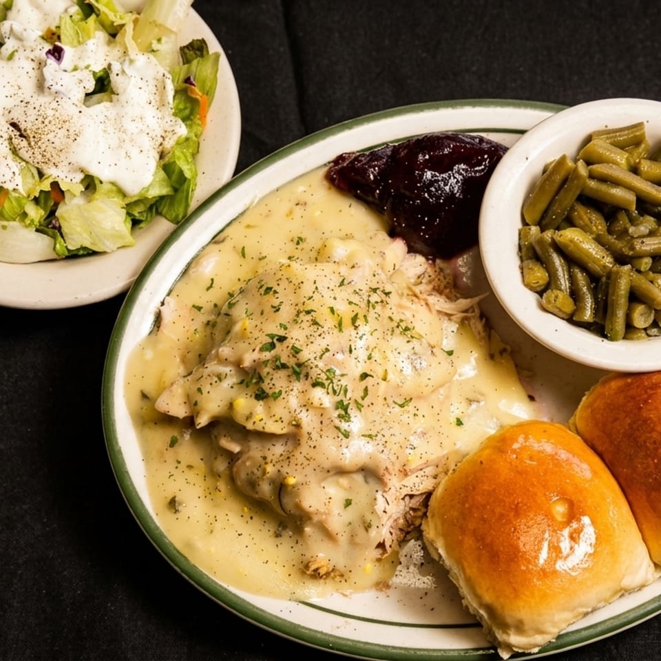 Chicken and dumplings with green beans, cranberry sauce, dinner rolls, and a side salad.